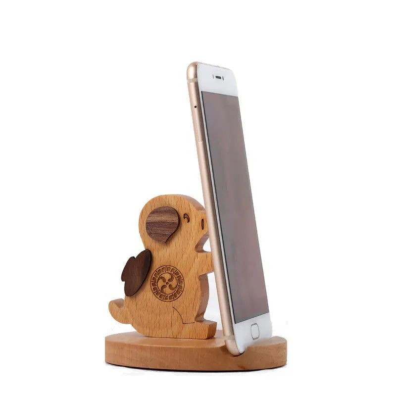 Beech wood mobile phone holder stand with coin slot and decorative carving.