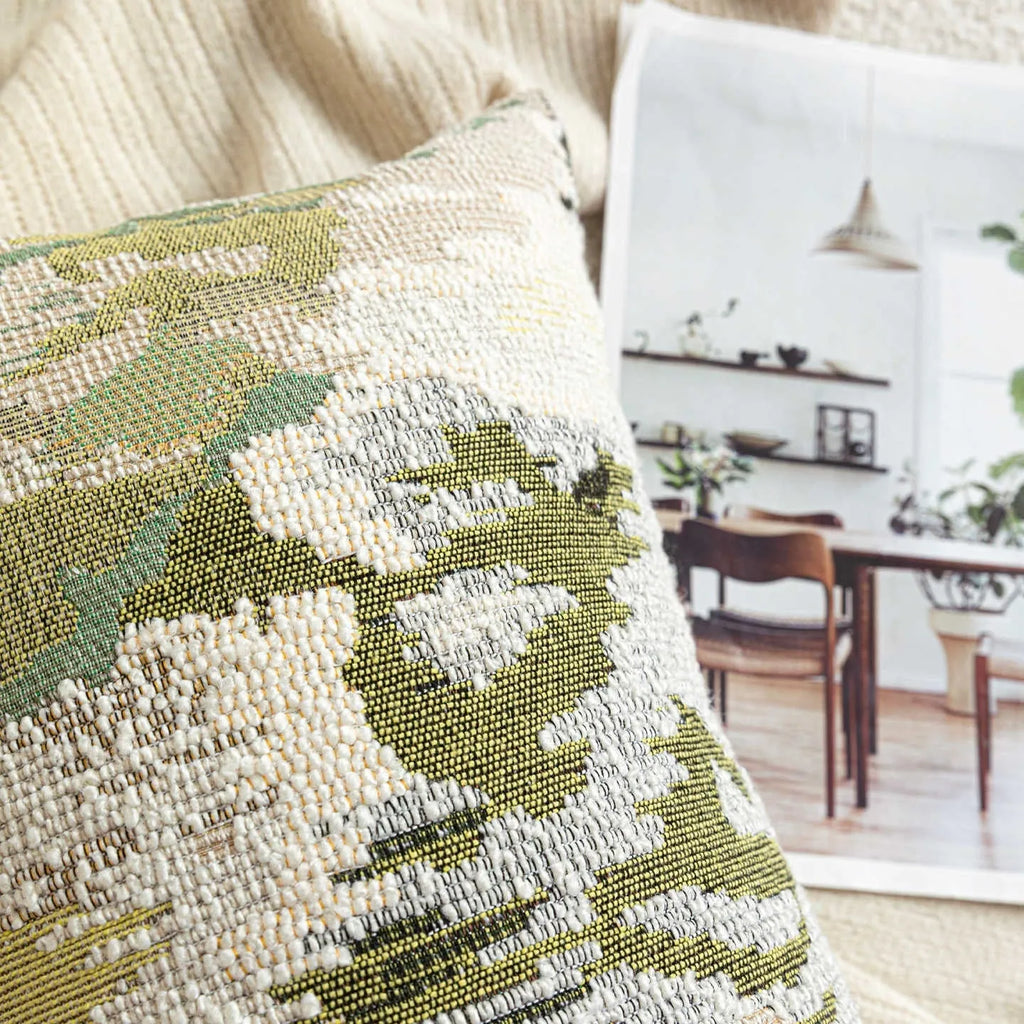 Antique green wool blend cushion with abstract spring flowers pattern, shown in square and lumbar sizes.