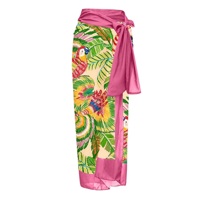 Pink floral print women's one-piece swimsuit with V-neck and matching skirt on beach