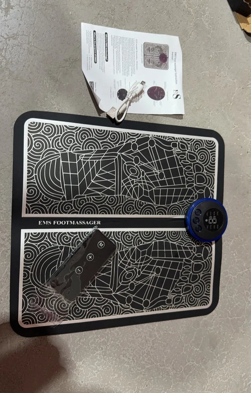 Leather foot massage cushion with LCD screen and wireless remote control on a floor