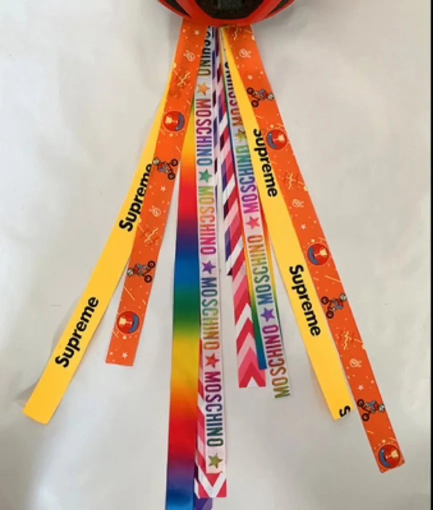 Colourful decorative ribbon streamers attached to a children safety helmet for skating or skiing