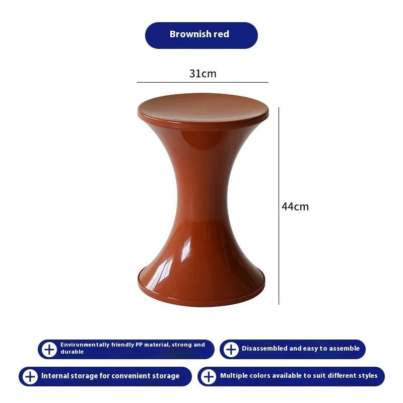 Plastic hourglass-shaped shoe changing stool in selected colour, shown in a home entryway setting.