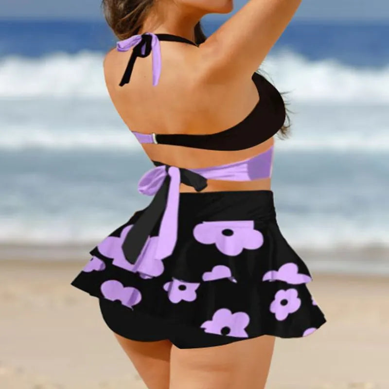 Purple women's lace-up bikini swimsuit set with a matching high-waisted skirt.