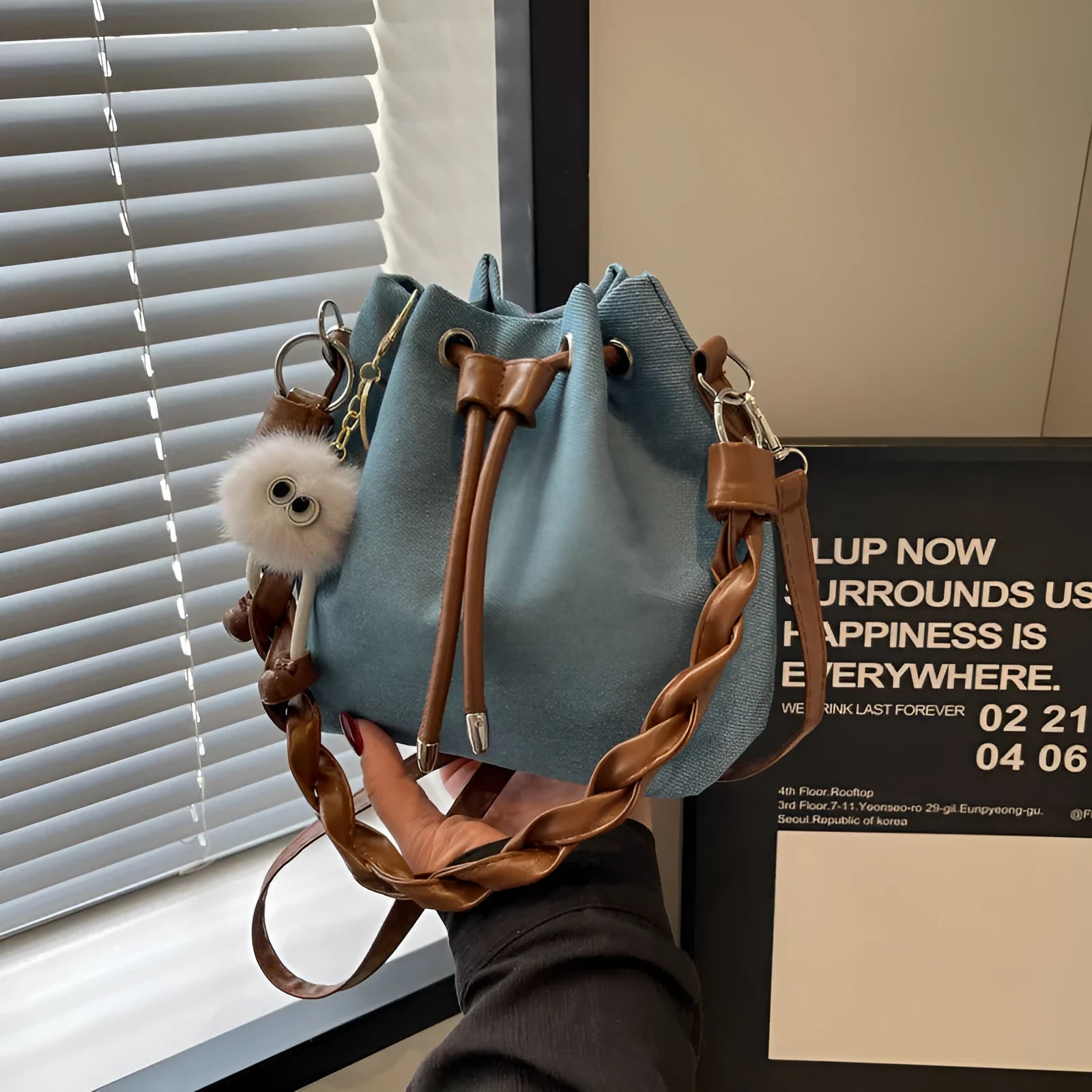 Blue synthetic leather cross-body bucket bag with adjustable strap and sandwich pocket