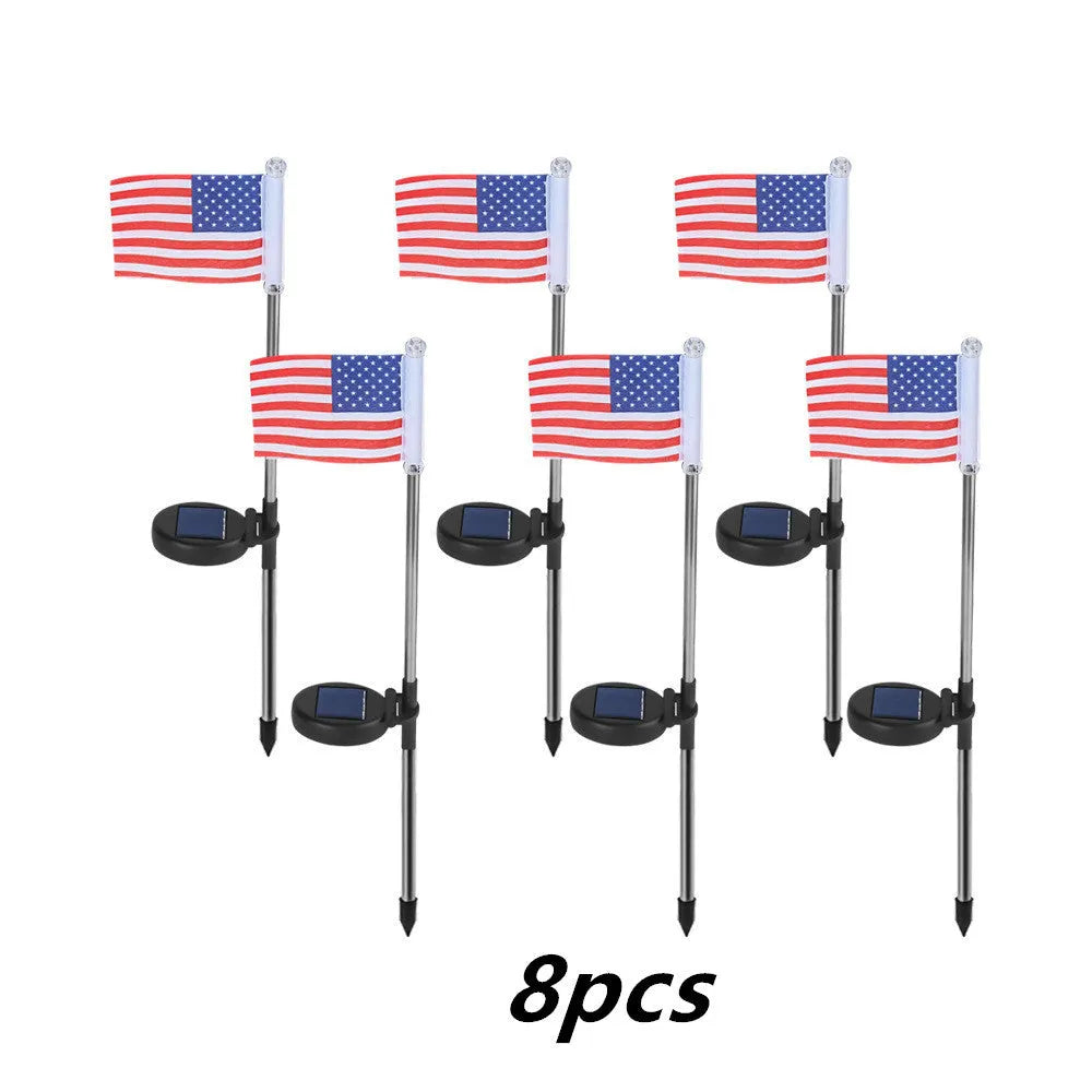 Solar-powered garden flag light displaying either American or British flag design with stainless steel pole and solar panel