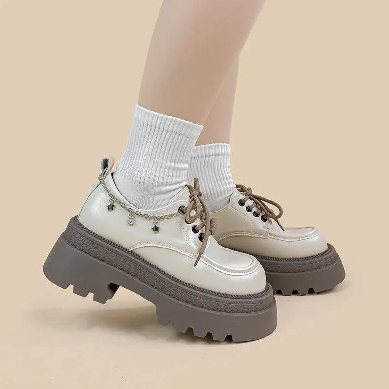 White platform Mary Jane shoes with chunky heel and front lace-up detail on a round toe.