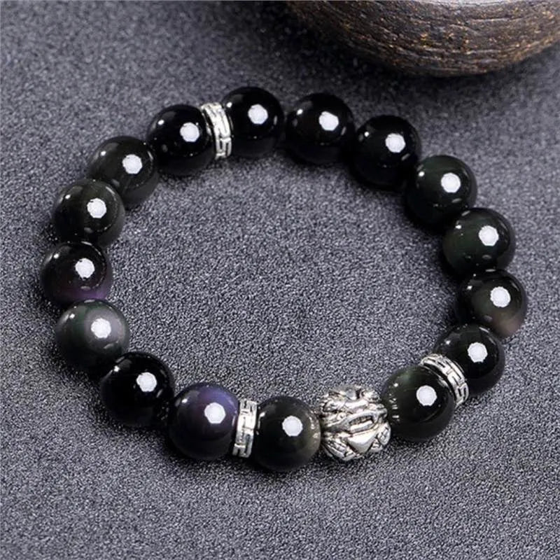 Natural obsidian bead bracelet with Silver 999 details and Cloud Year Of design on a wrist.