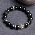 Natural obsidian bead bracelet with Silver 999 details and Cloud Year Of design on a wrist.