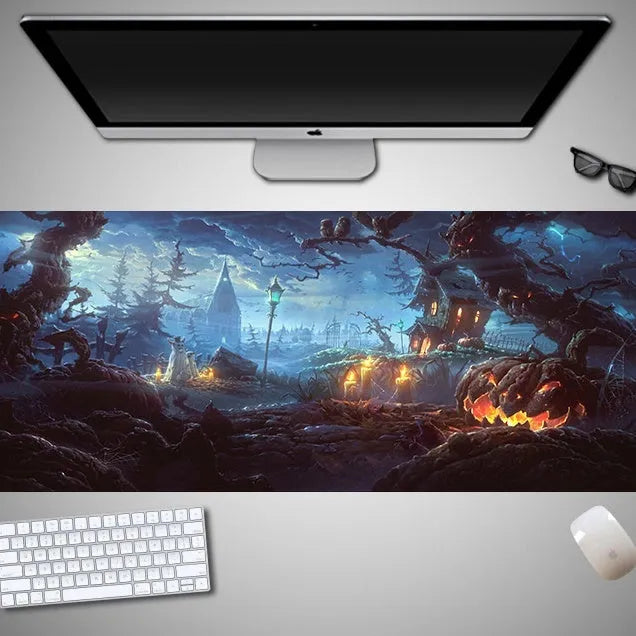 Oversized black Halloween-themed mouse pad with spooky artwork on a desk next to a gaming mouse.