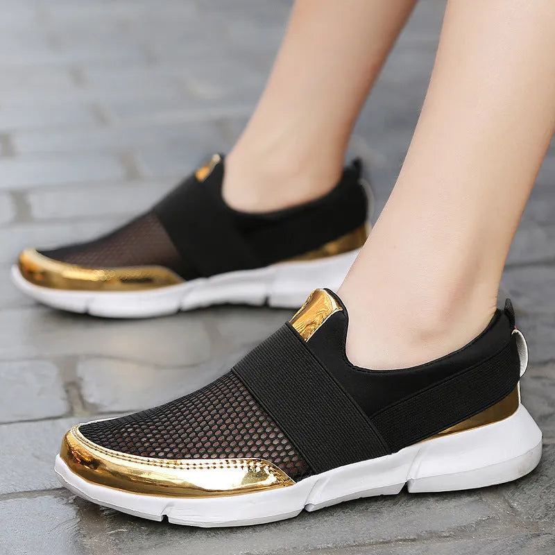 Low-cut blue women's casual sneakers with mesh upper on a hard floor surface.