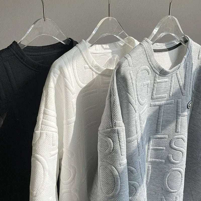 Man wearing a grey loose-fit T-shirt with a raised 3D retro letter print on the front.