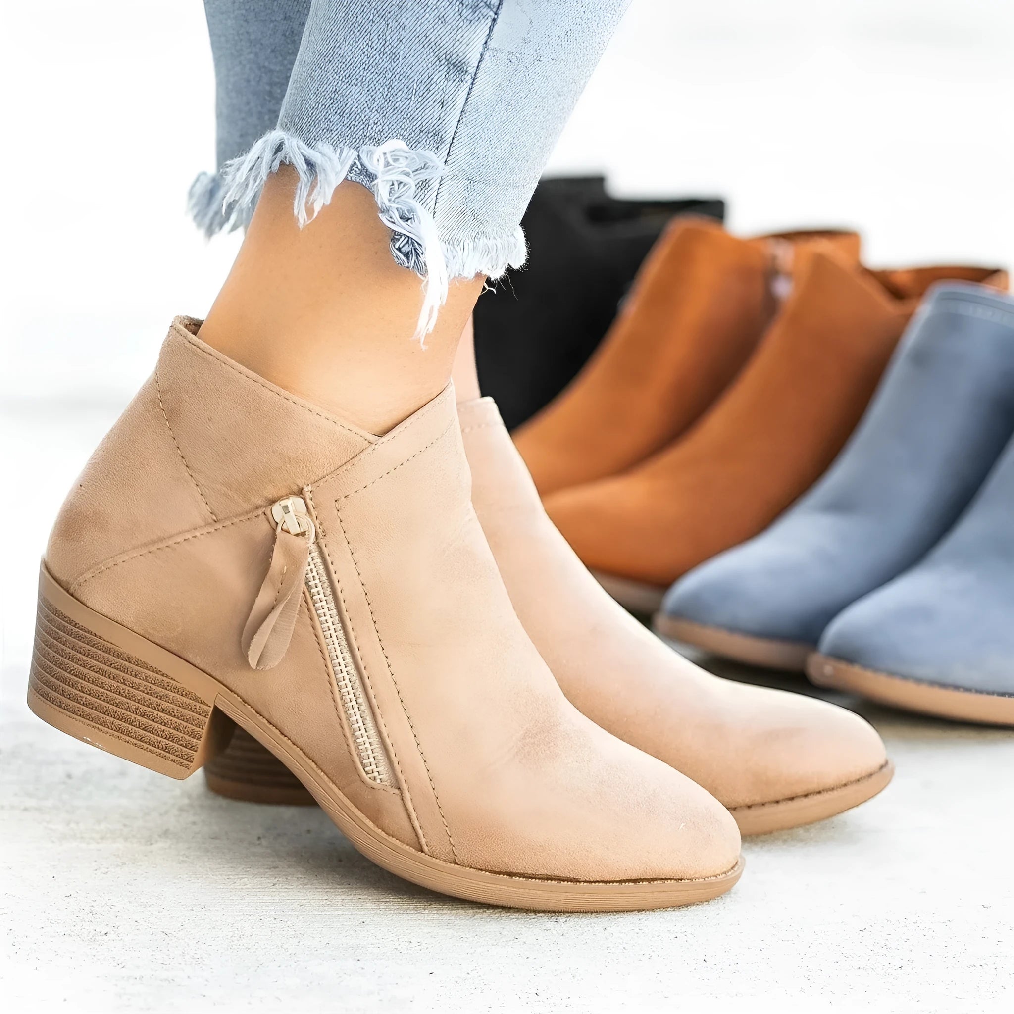 Blue Dr Martens women's suede ankle boots with a side zip and chunky heel on a white background.