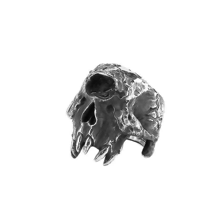 A silver-toned alloy ring with a raised one-eyed skull design on a black background.