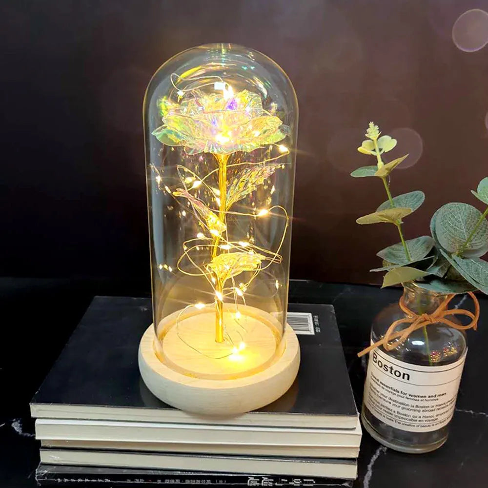 Simulated pink silk rose inside a glass dome with glowing LED fairy lights