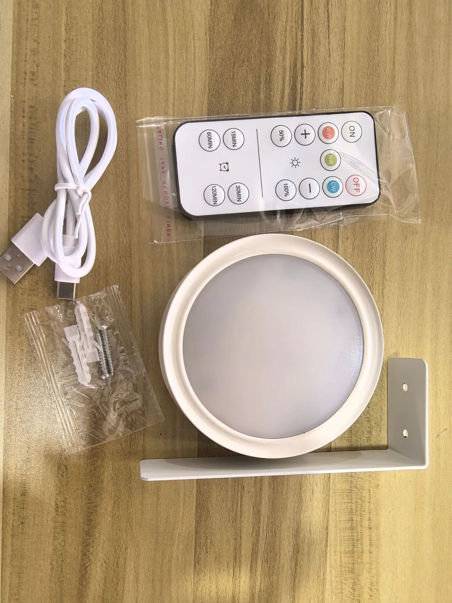 Wireless rechargeable LED painting lamp with magnetic belt attached to a metal frame, remote control nearby.