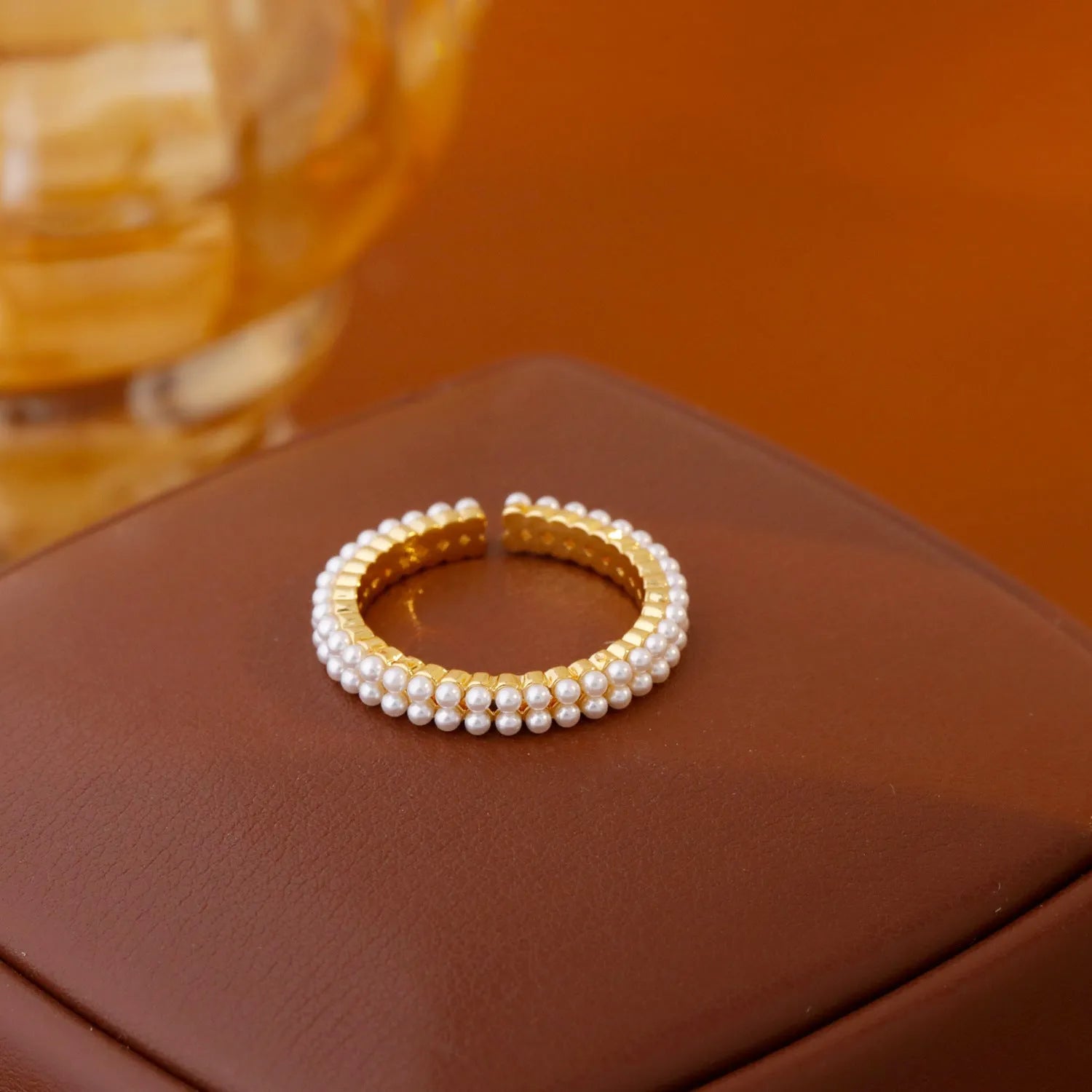 Gold geometric open mouth ring with round decorative elements on female hand