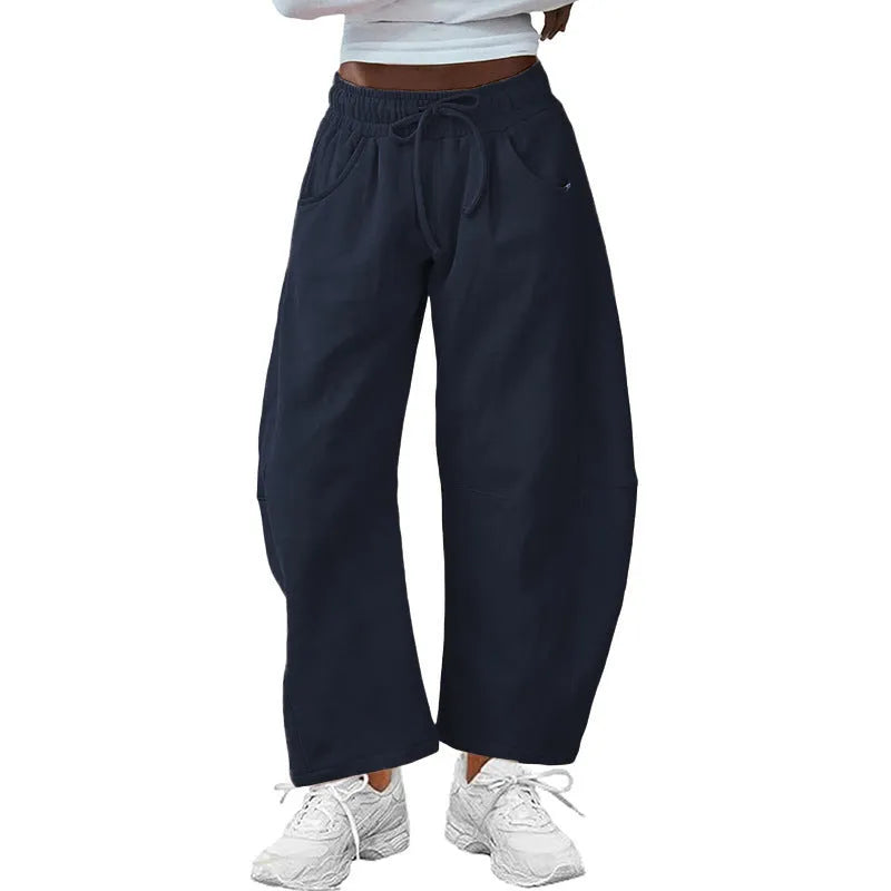 Loose grey cropped sweatpants with elastic drawstring waist and pockets on a mannequin