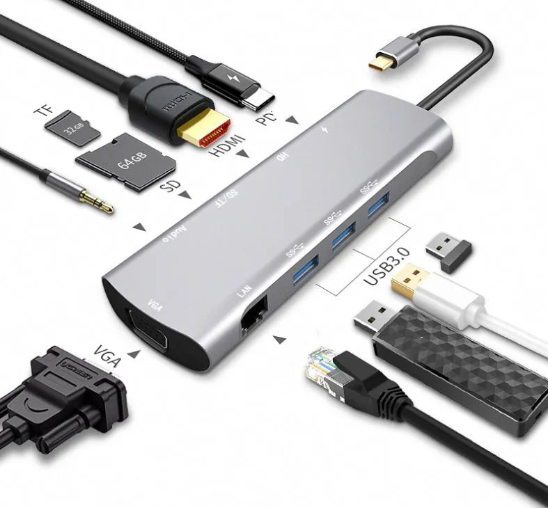 Grey aluminium USB-C docking station with HDMI, VGA, USB, and charging ports on a desk.