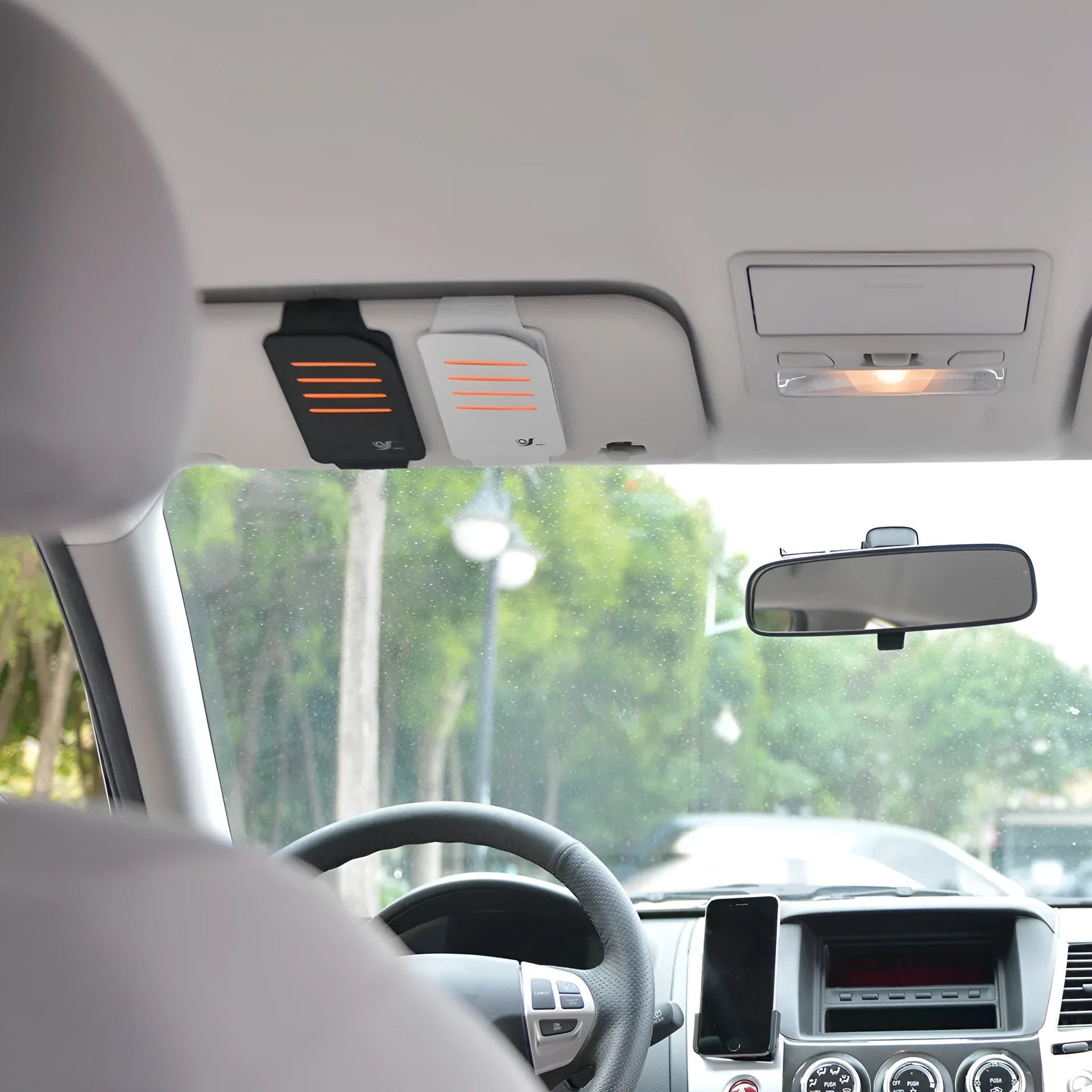 Car dashboard storage organiser with sun visor panels attached to a windscreen.
