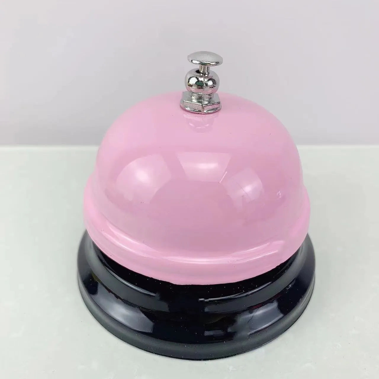 A multi-colour iron hand bell for games, classrooms, or restaurant service.