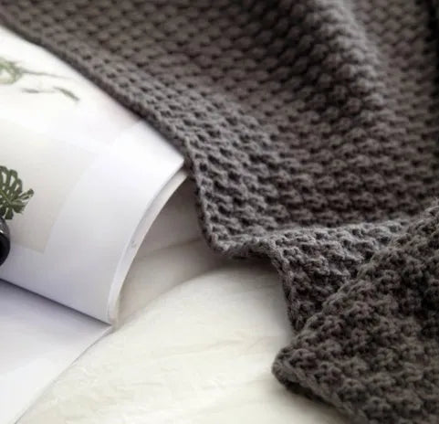 Nordic fringed knit ball acrylic blanket in beige colour on a sofa