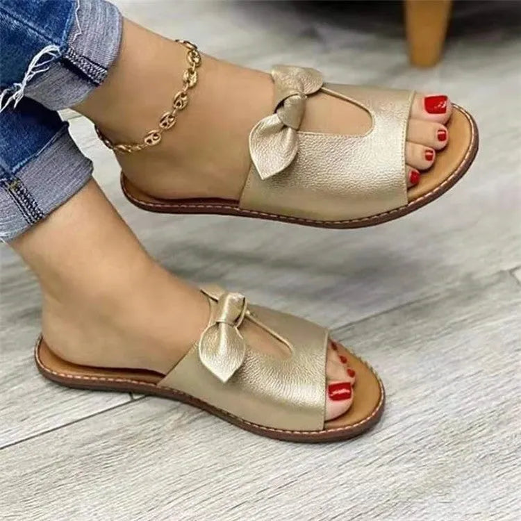 Ladies casual sandals with fish mouth front and decorative bow in black, pink, and gold colours.