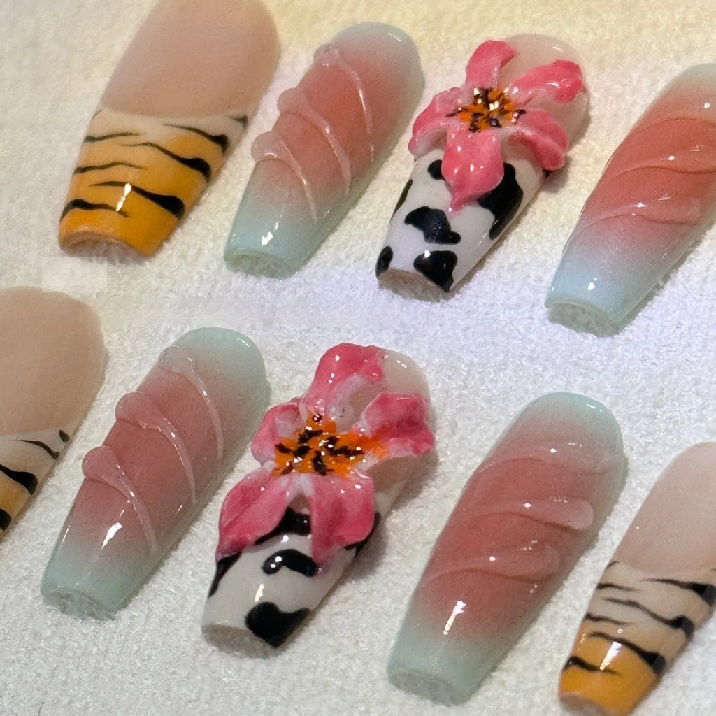 Close-up of hand-carved acrylic press-on nails with a Lily zebra pattern, floral, and leopard print design.