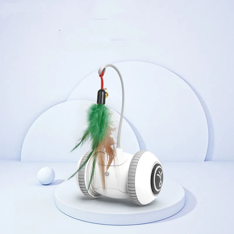 White and grey automatic interactive cat toy with interchangeable feather accessory on a floor, USB cable attached