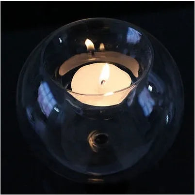 Clear round hollow glass candle holder for a tea light on a table
