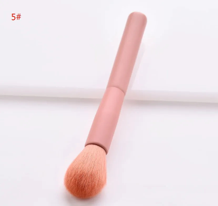 Ten makeup brushes with wooden handles arranged showing different brush head types including powder, foundation and double-headed tools