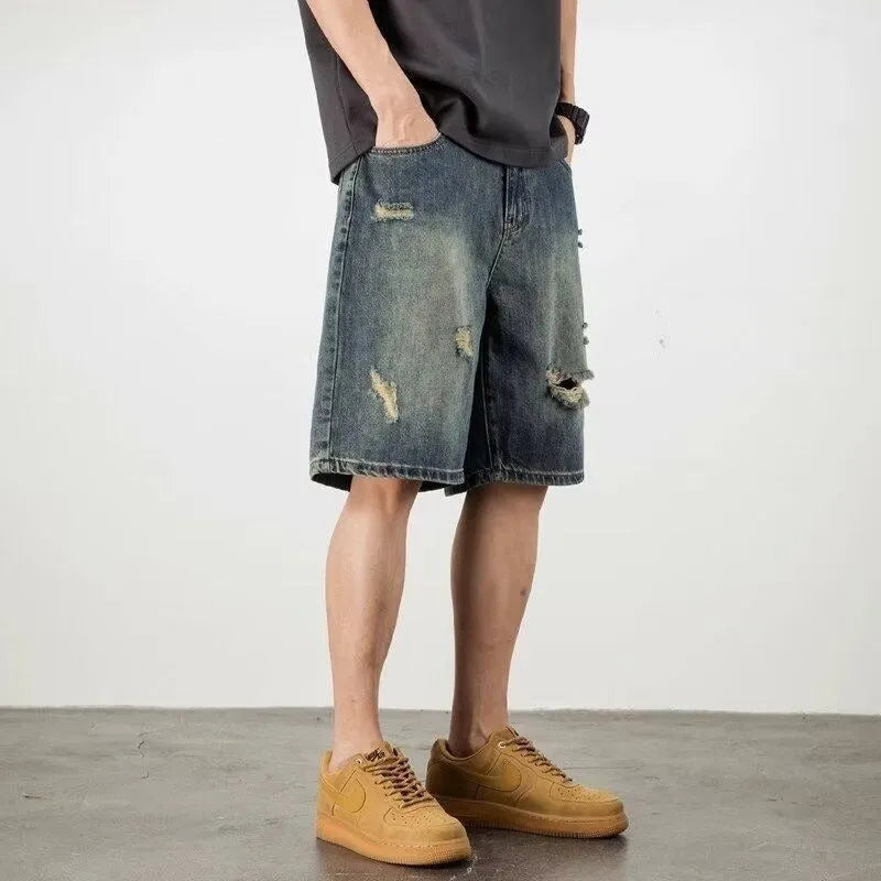 Blue retro-style men's denim shorts with a loose fit, distressed holes, and a straight-leg cut.