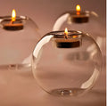 Clear round hollow glass candle holder for a tea light on a table