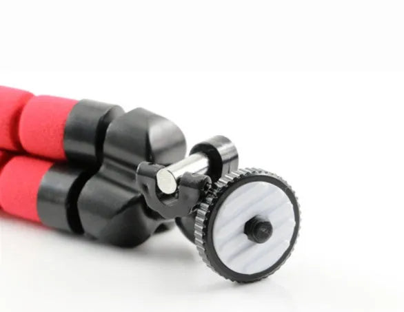 Black flexible octopus tripod with bent legs wrapped around a pole, showing smartphone mount with 1/4-20 screw.