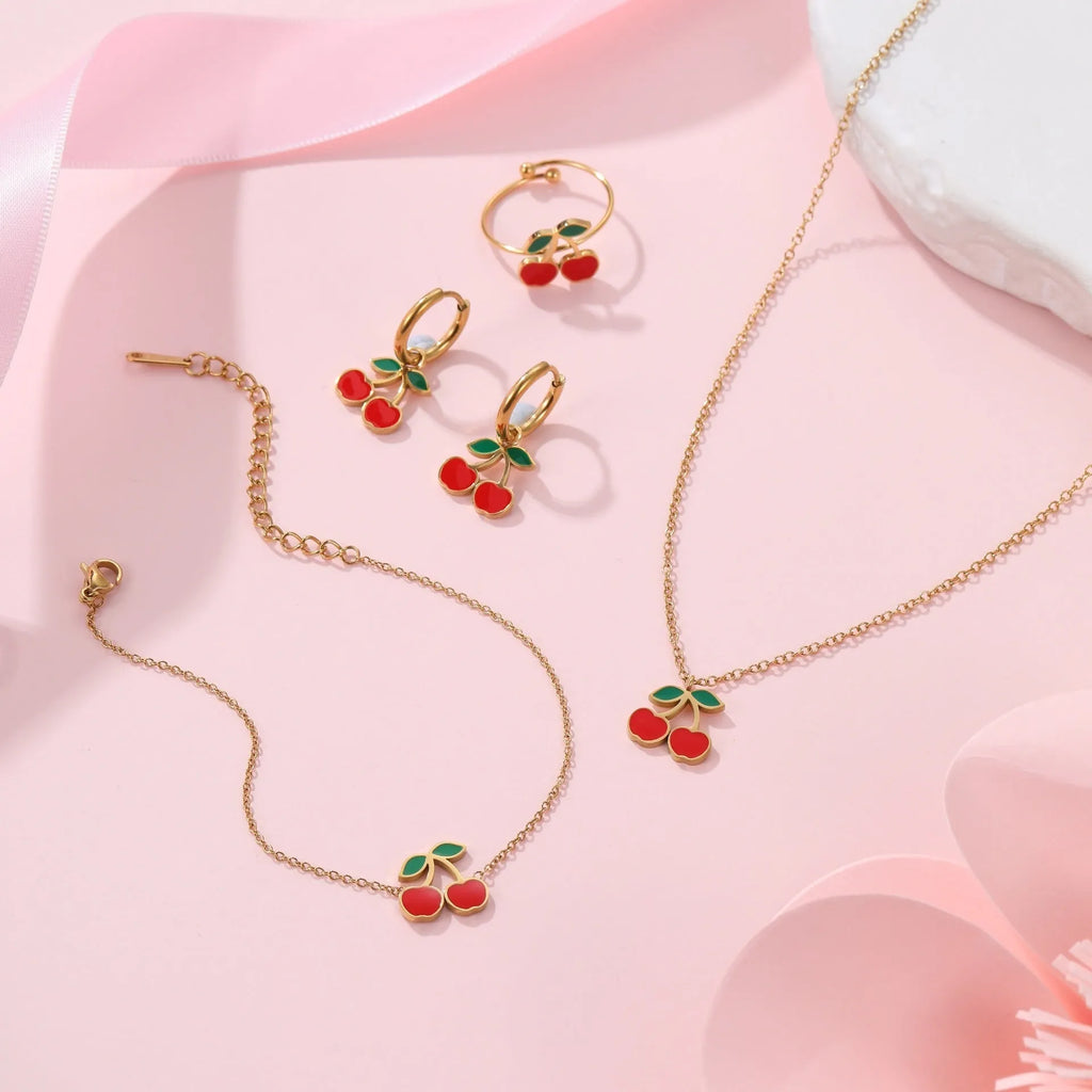 Cherry jewellery set showing necklace, bracelet, earrings, and ring with 18K gold electroplating on stainless steel