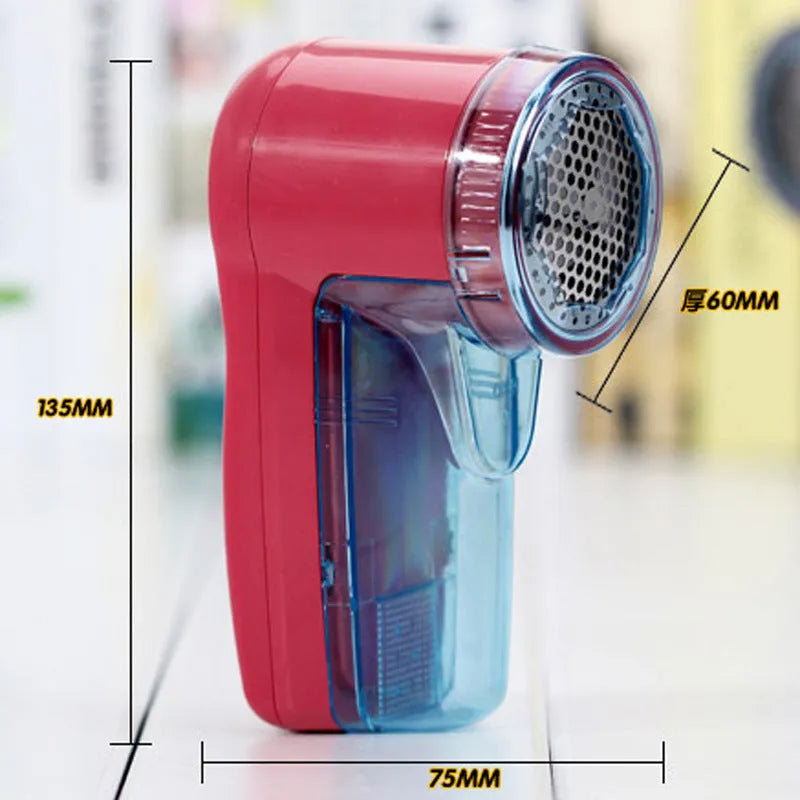 White handheld electric lint remover for clothing on a grey background showing its compact size.