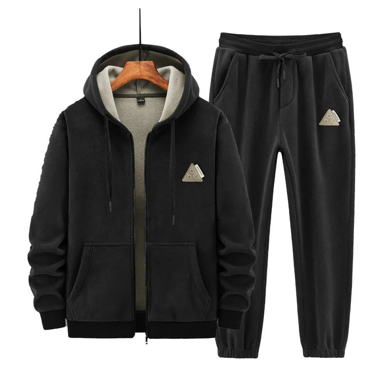 Man wearing a grey hooded zip-up sports jacket and matching trousers from a casual sports suit set.