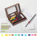Miniature walnut wood watercolour paint box open to show pigment pans and wooden palette