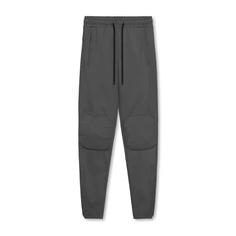 Men's grey loose-fit running pants with ankle ties on a gym floor