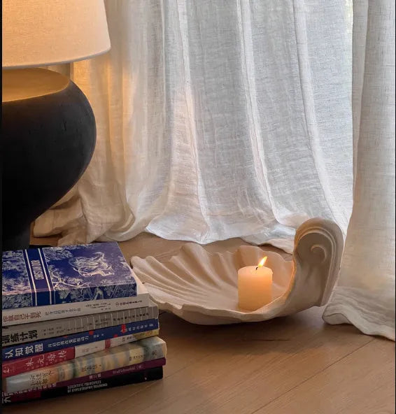 White resin shell-shaped fruit plate ornament on table setting