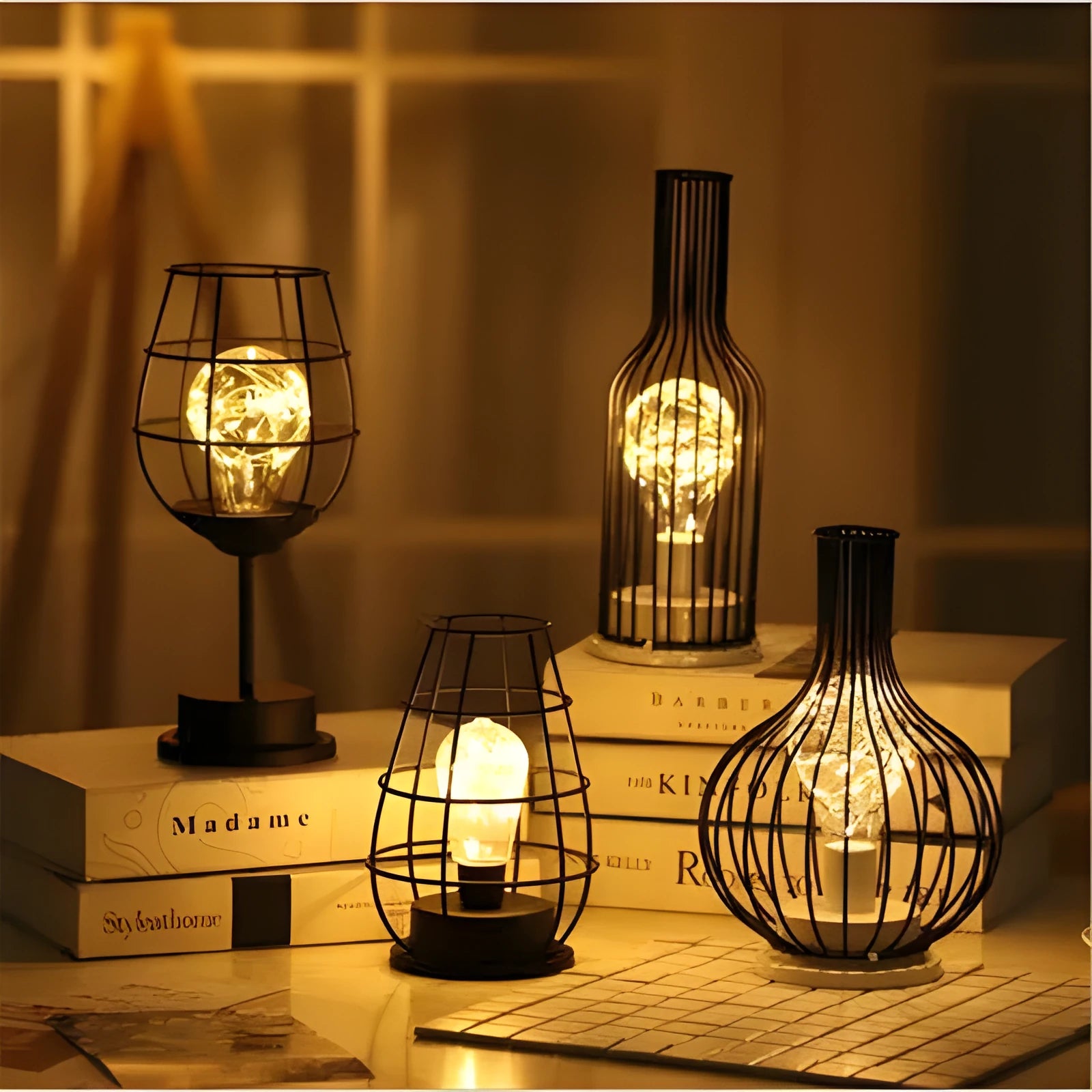 Minimalist hollow iron table lamp in red wine glass style on a wooden desk.