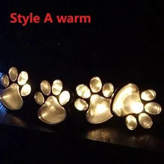 Black solar powered animal paw print LED garden lights set with four paw shapes and solar panel