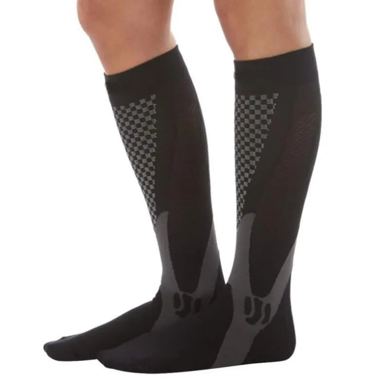 Graduated compression socks for men and women in black, shown laid flat.
