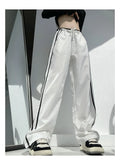 Navy blue loose straight-leg trousers with contrast ribbon trim and a slimming drape