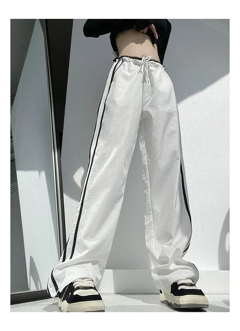 Navy blue loose straight-leg trousers with contrast ribbon trim and a slimming drape