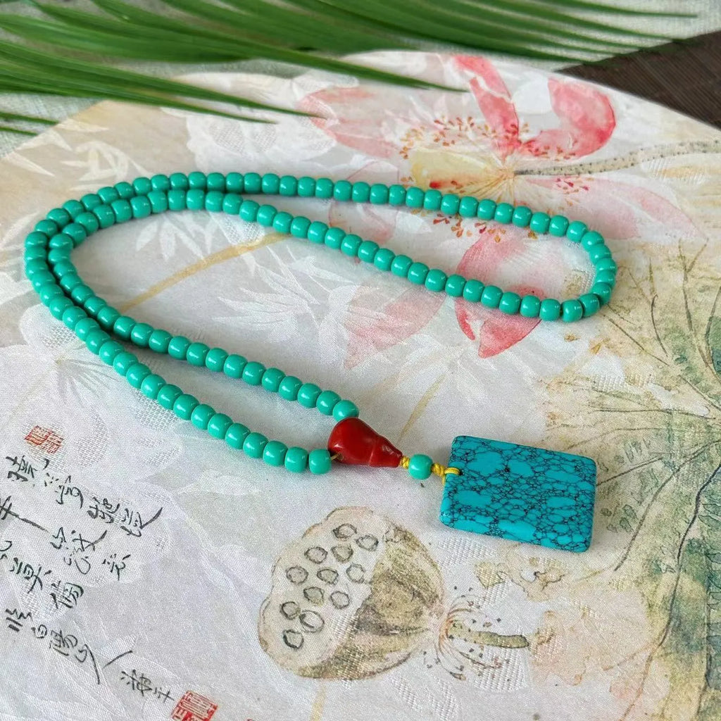 Hand-woven turquoise mesh flower lucky pendant on an adjustable ball bead necklace chain.