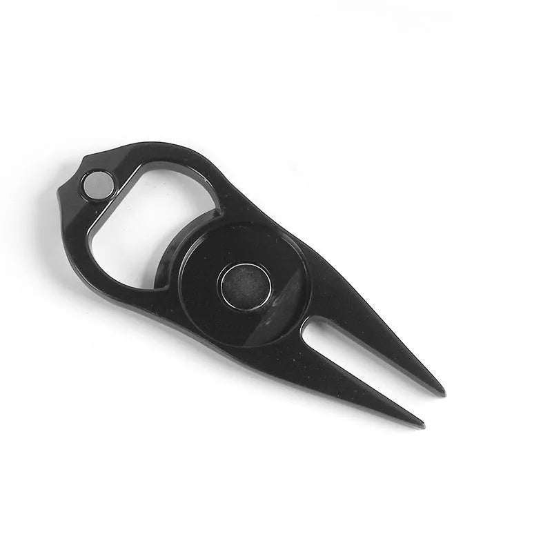 Black zinc alloy golf ball yoke fork with integrated bottle opener tool on green turf.