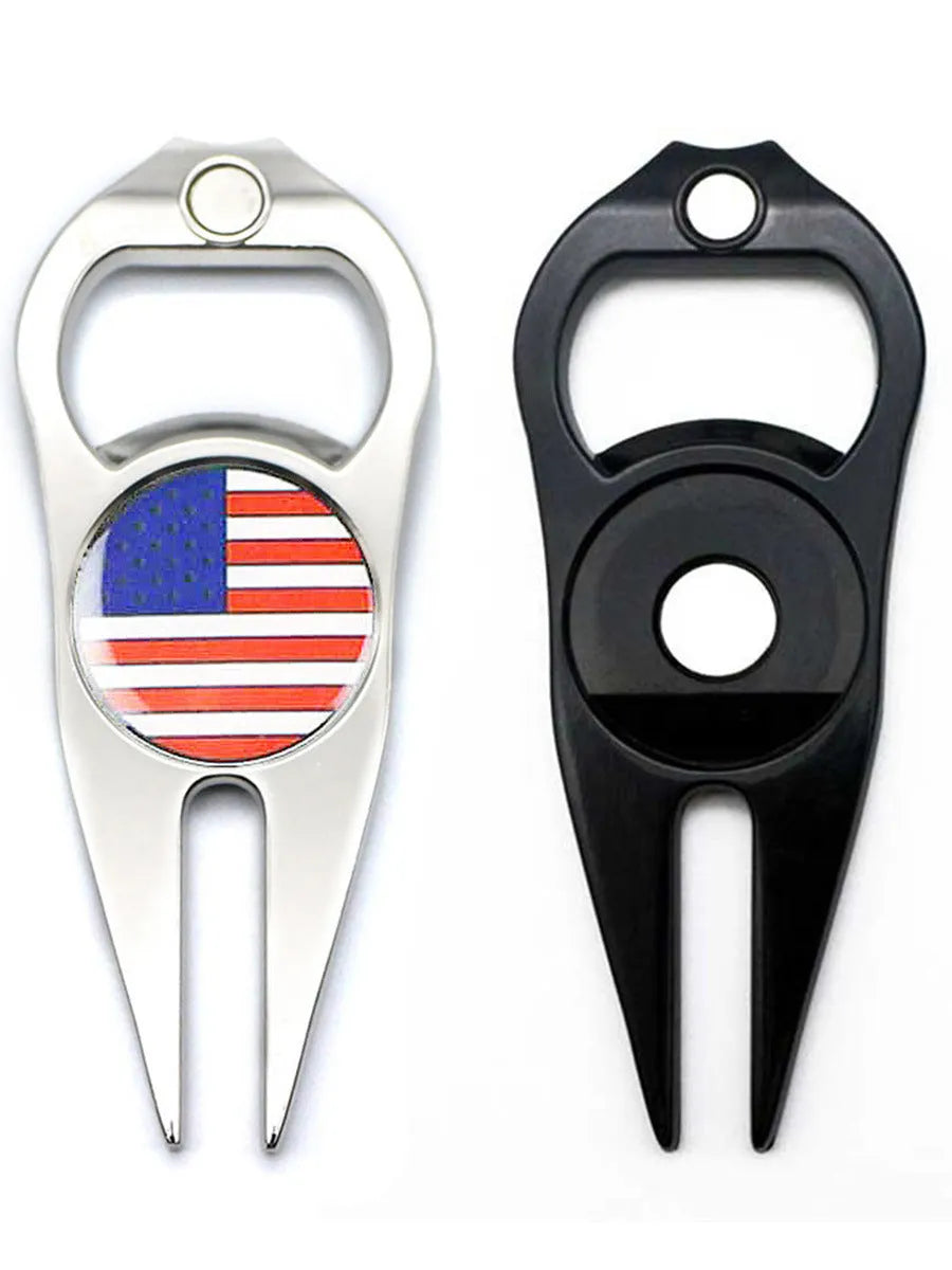 Black zinc alloy golf ball yoke fork with integrated bottle opener tool on green turf.