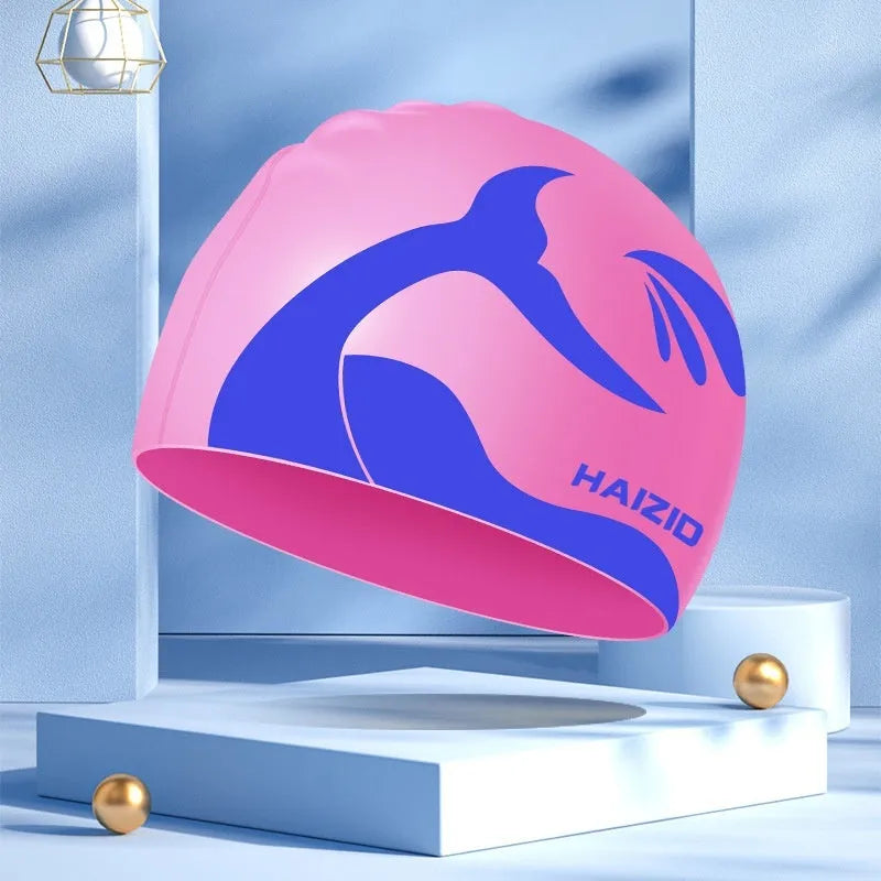 Silicone swimming cap with whale tail pattern and built-in ear protectors in assorted colours.