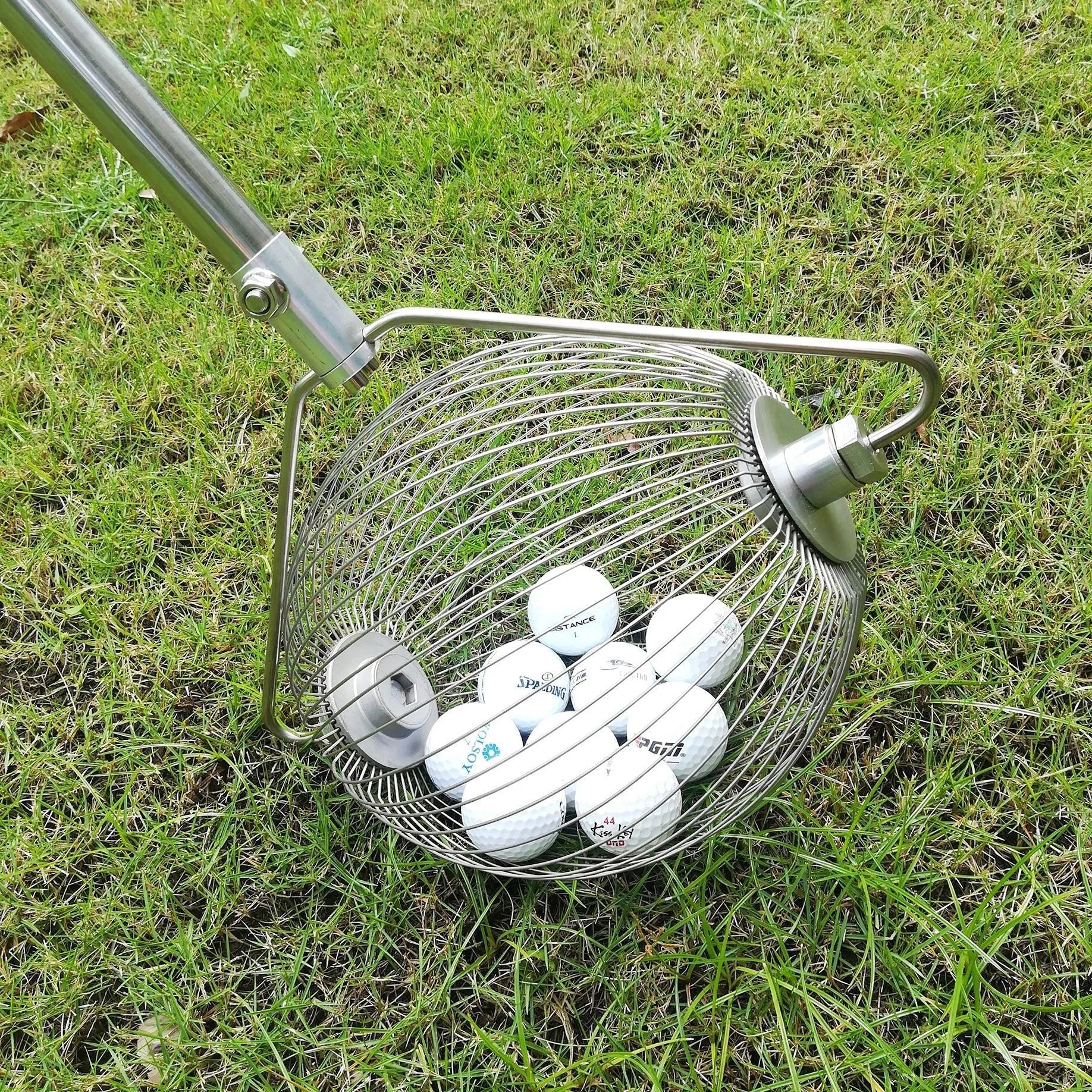 Metallic coloured 304 stainless steel golf ball picker retriever on a green.