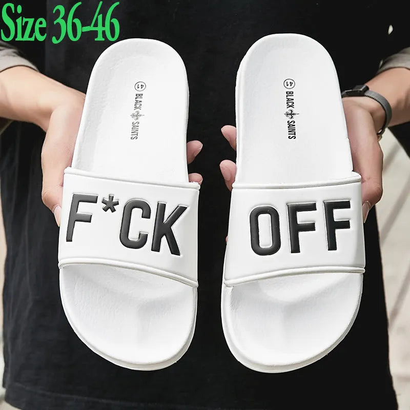 Men's black and white open-toe slippers with a textured rubber sole on a plain background